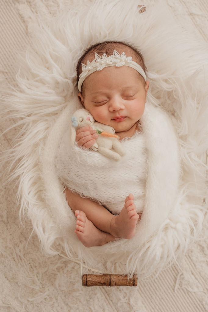 Recém-nascida enrolada em wrap dormindo em ensaio newborn